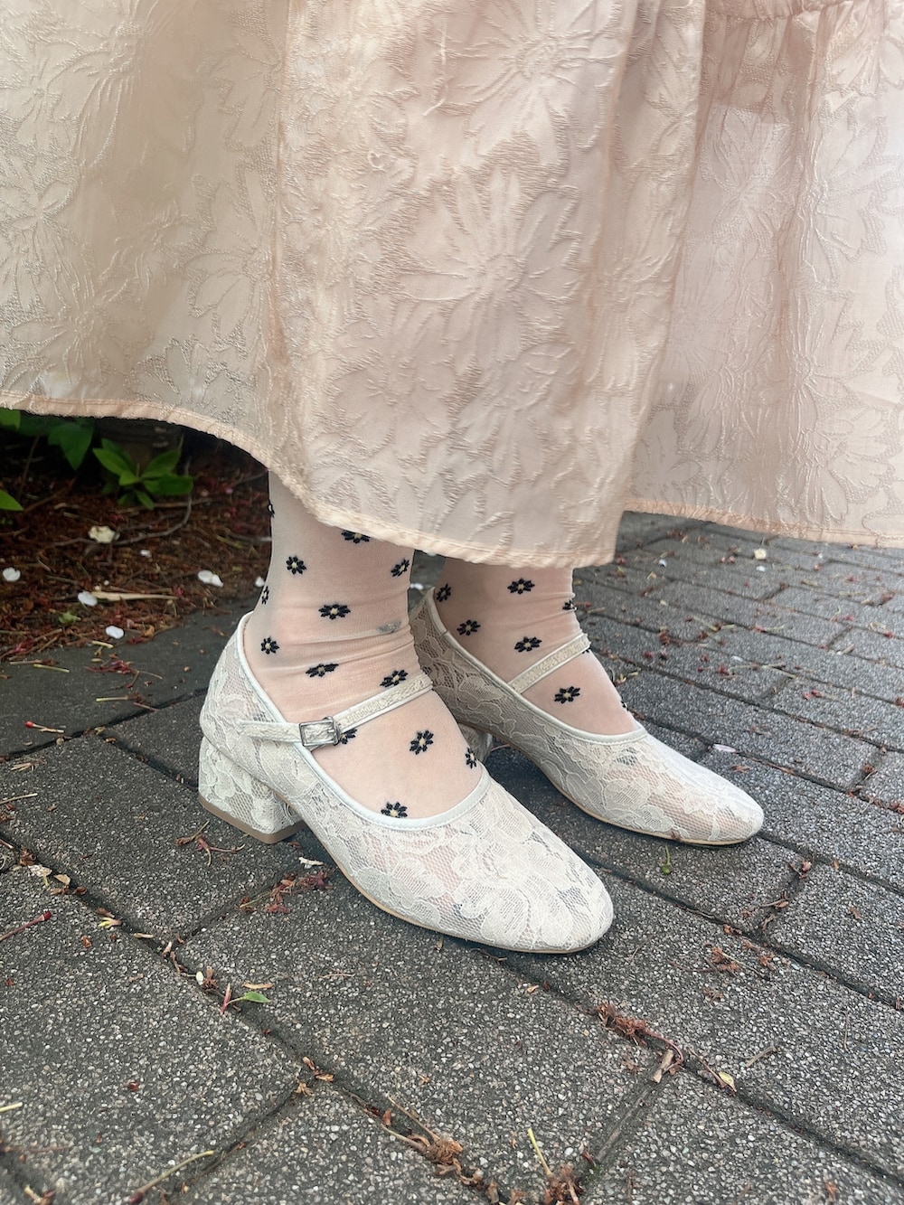 ホワイト系のパンプス、ピンク系のワンピース、ピンク系のキャミソールを着用したレディースの春コーディネートの3枚目の写真