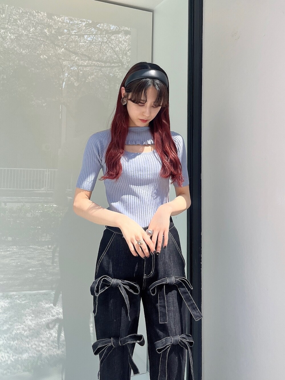 ブラック系のデニムパンツ、ホワイト系のサンダル、ブルー系のニット/セーターを着用したレディースの春コーディネートの2枚目の写真