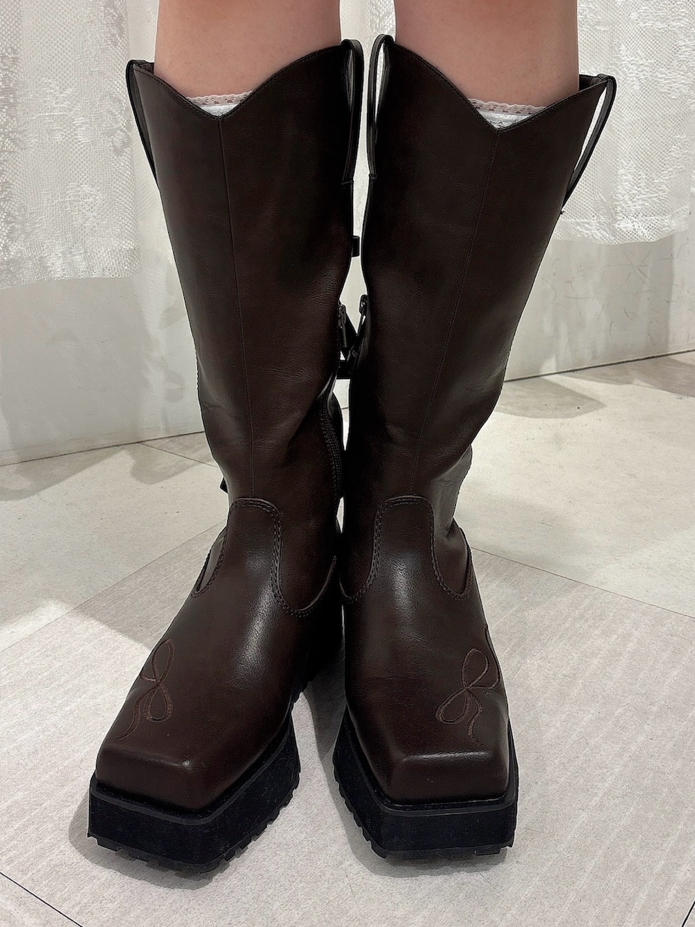 ブラウン系のスカート、ブラウン系のブーツ、グレー系のカーディガン/ボレロを着用したレディースの夏コーディネートの6枚目の写真