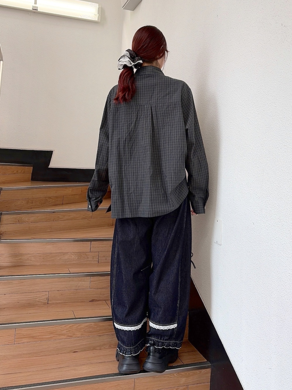 グリーン系のシャツ/ブラウス、ブルー系のデニムパンツ、ブラック系のスニーカーを着用したレディースの秋コーディネートの3枚目の写真