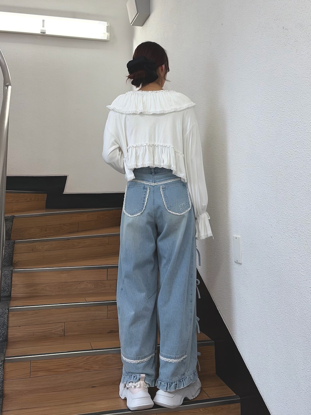 ブルー系のデニムパンツ、ピンク系のスニーカー、ピンク系のTシャツ/カットソーを着用したレディースの夏コーディネートの2枚目の写真