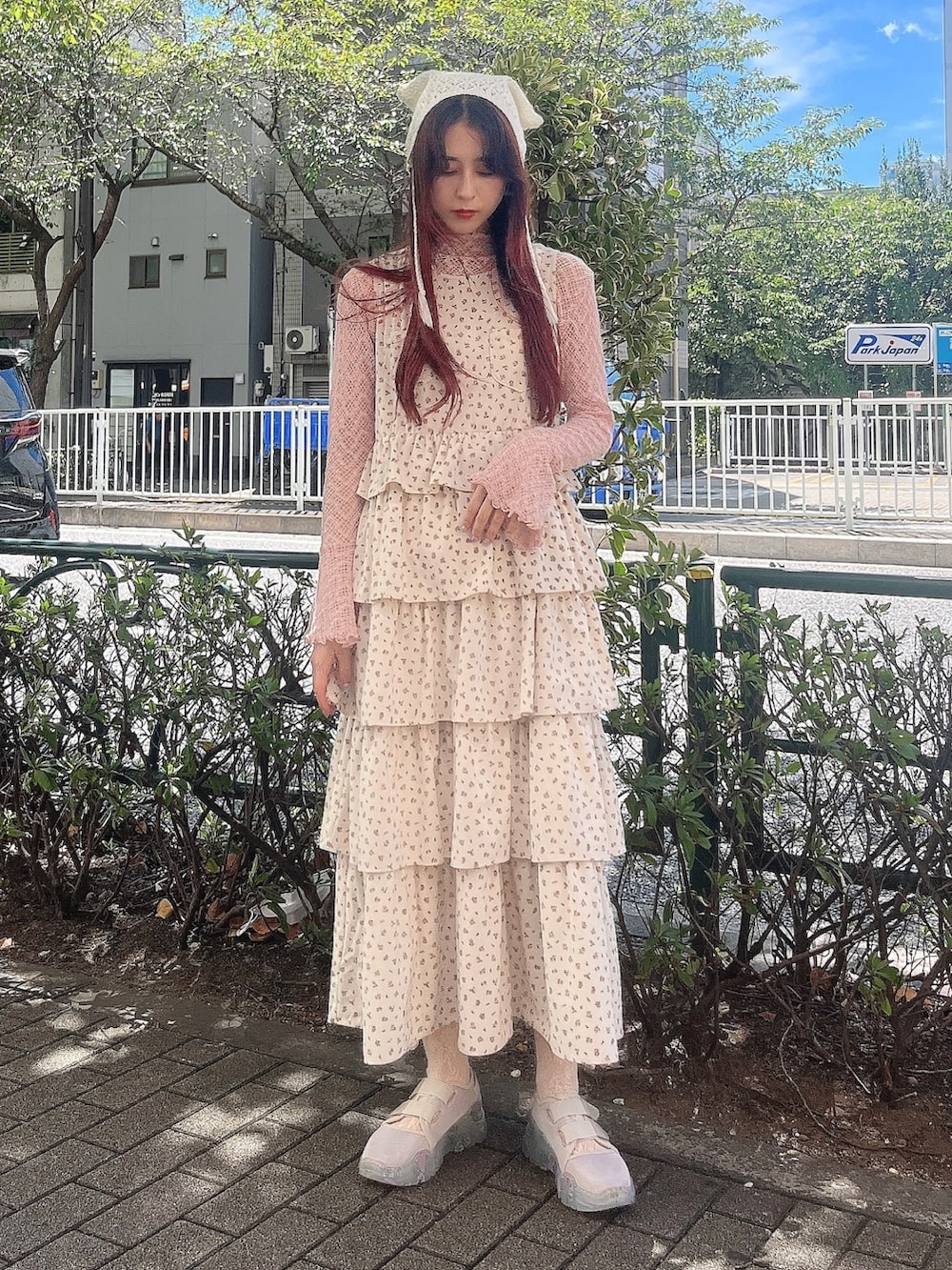 ピンク系のTシャツ/カットソー、ホワイト系のジャンパースカート、ベージュ系のスニーカーを着用したレディースの秋コーディネートの4枚目の写真