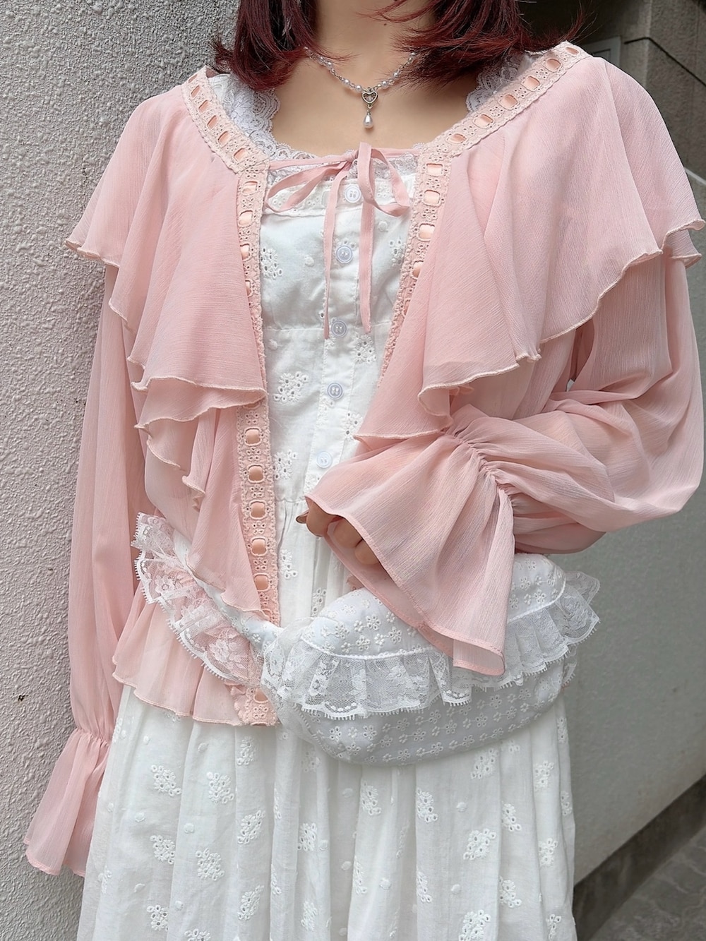 ピンク系のカーディガン/ボレロ、ホワイト系のワンピース、ブラック系のバレエシューズを着用したレディースの春コーディネートの6枚目の写真