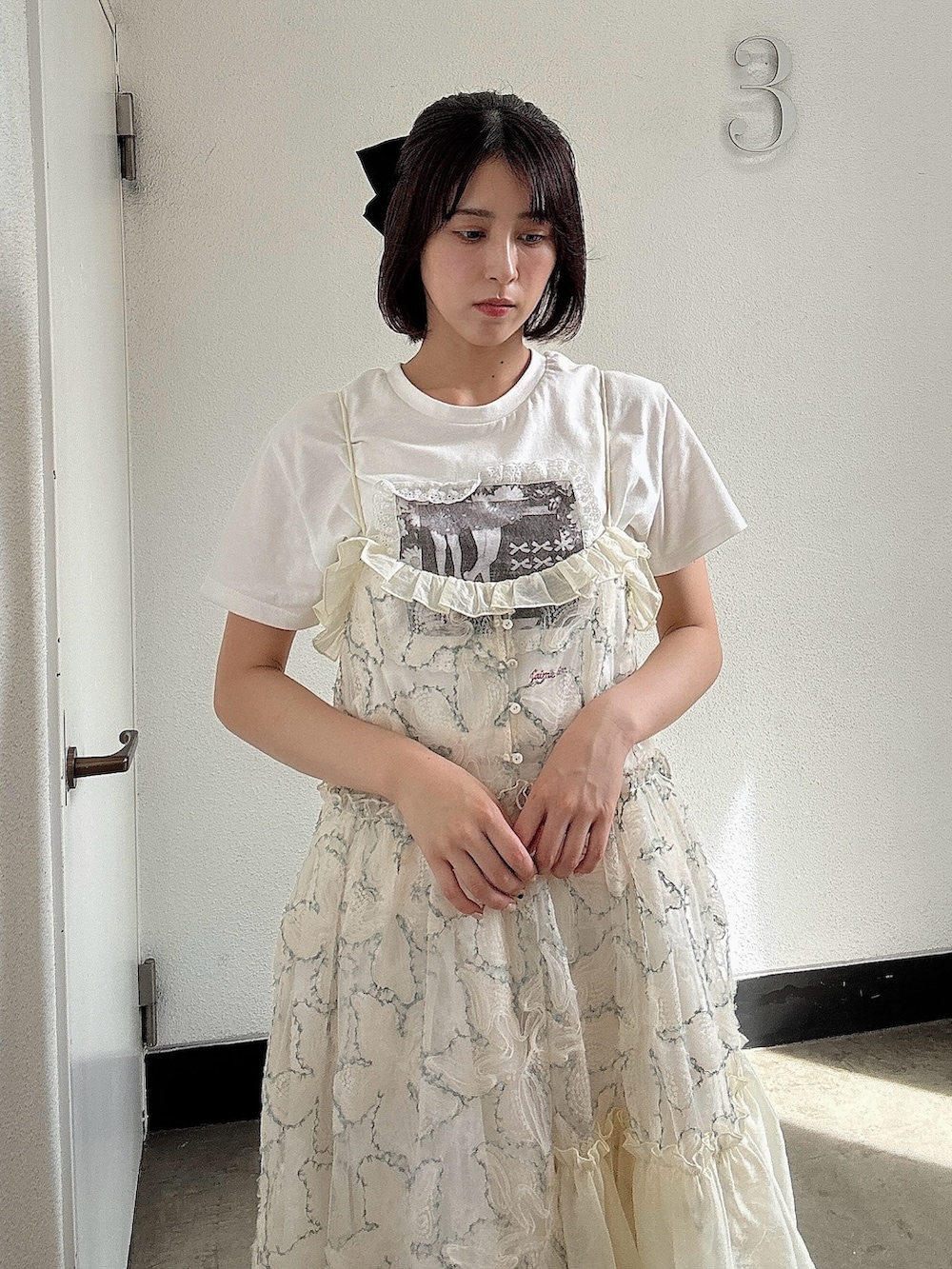 グリーン系のワンピース、ブラウン系のブーツ、ホワイト系のTシャツ/カットソーを着用したレディースの夏コーディネートの3枚目の写真