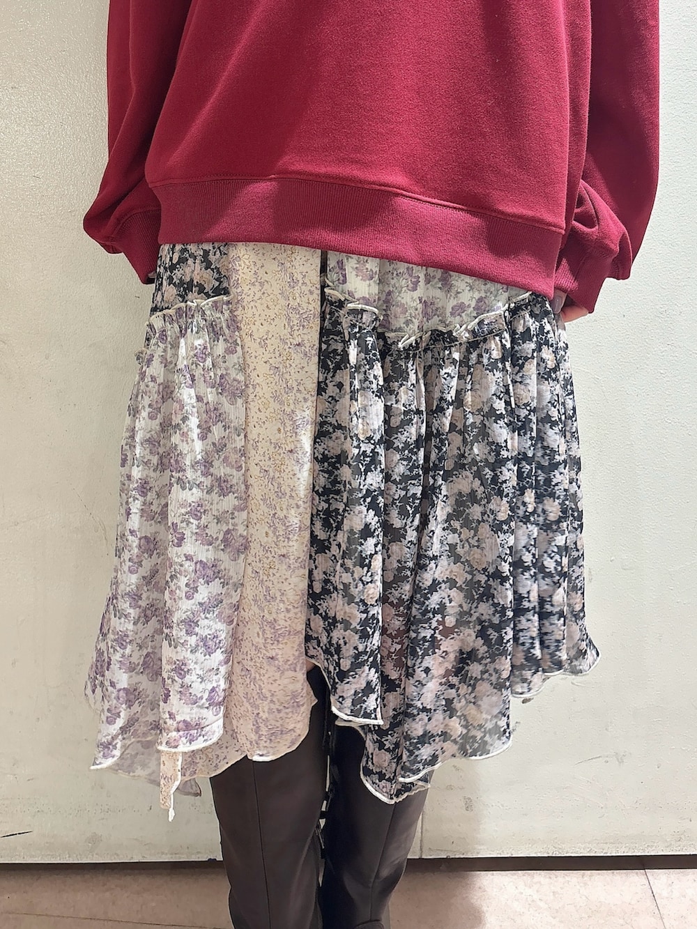 レッド系のスウェット、ブラック系のスカート、ブラウン系のブーツを着用したレディースの秋コーディネートの6枚目の写真