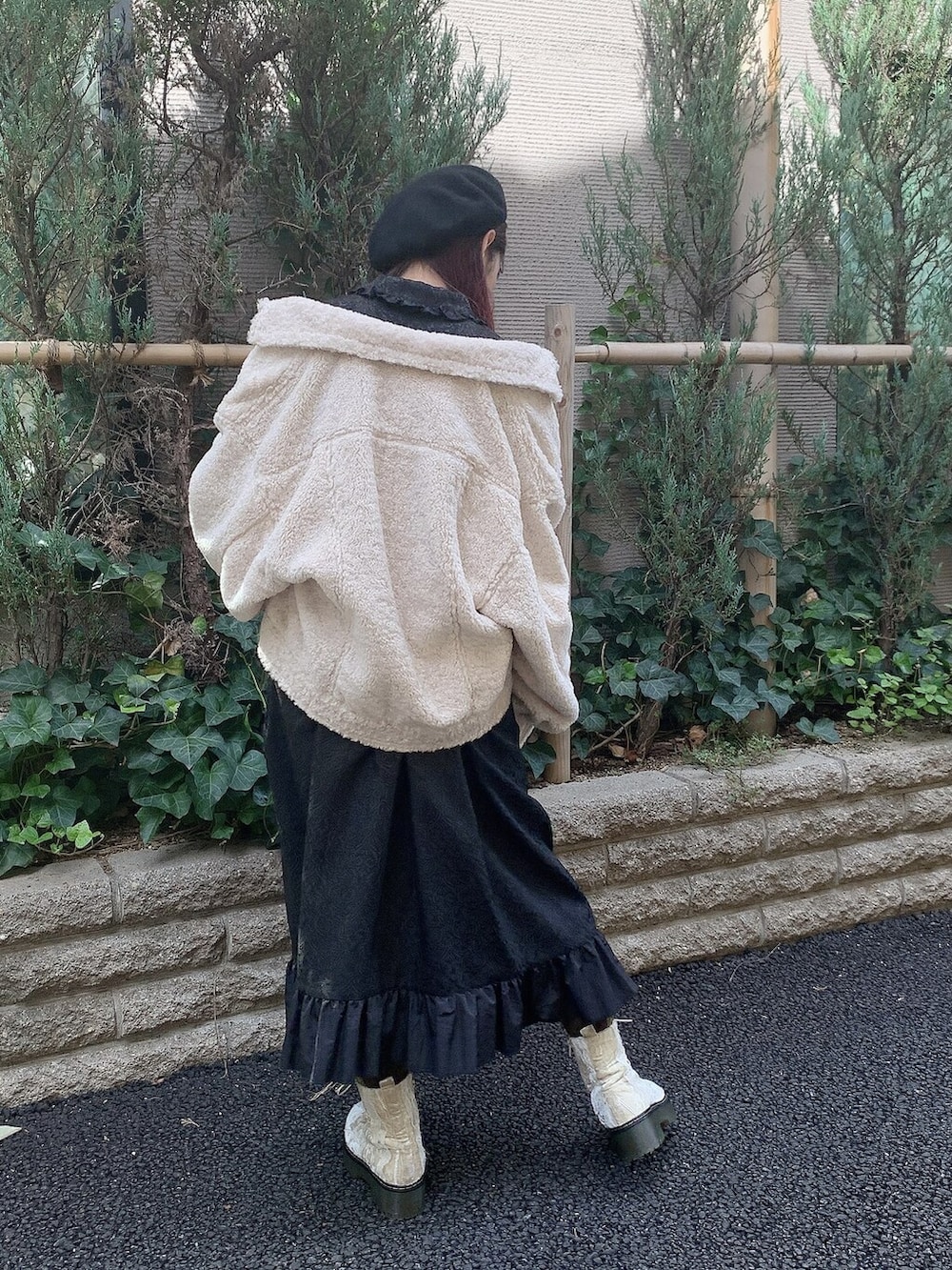 ブラック系のワンピース、ホワイト系のブーツ、ホワイト系のカバーオールを着用したレディースの秋コーディネートの2枚目の写真