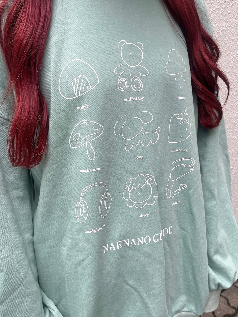 グリーン系のスウェット、ブラック系のスカート、ブラック系のブーツを着用したレディースの秋コーディネートの3枚目の写真