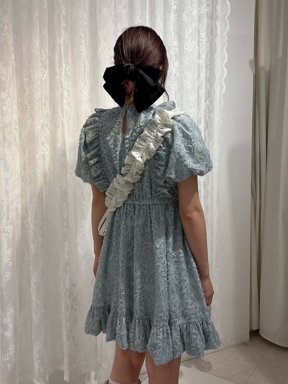 ブルー系のワンピース、ホワイト系のショルダーバッグ、ピンク系のブーツを着用したレディースの春コーディネートの4枚目の写真