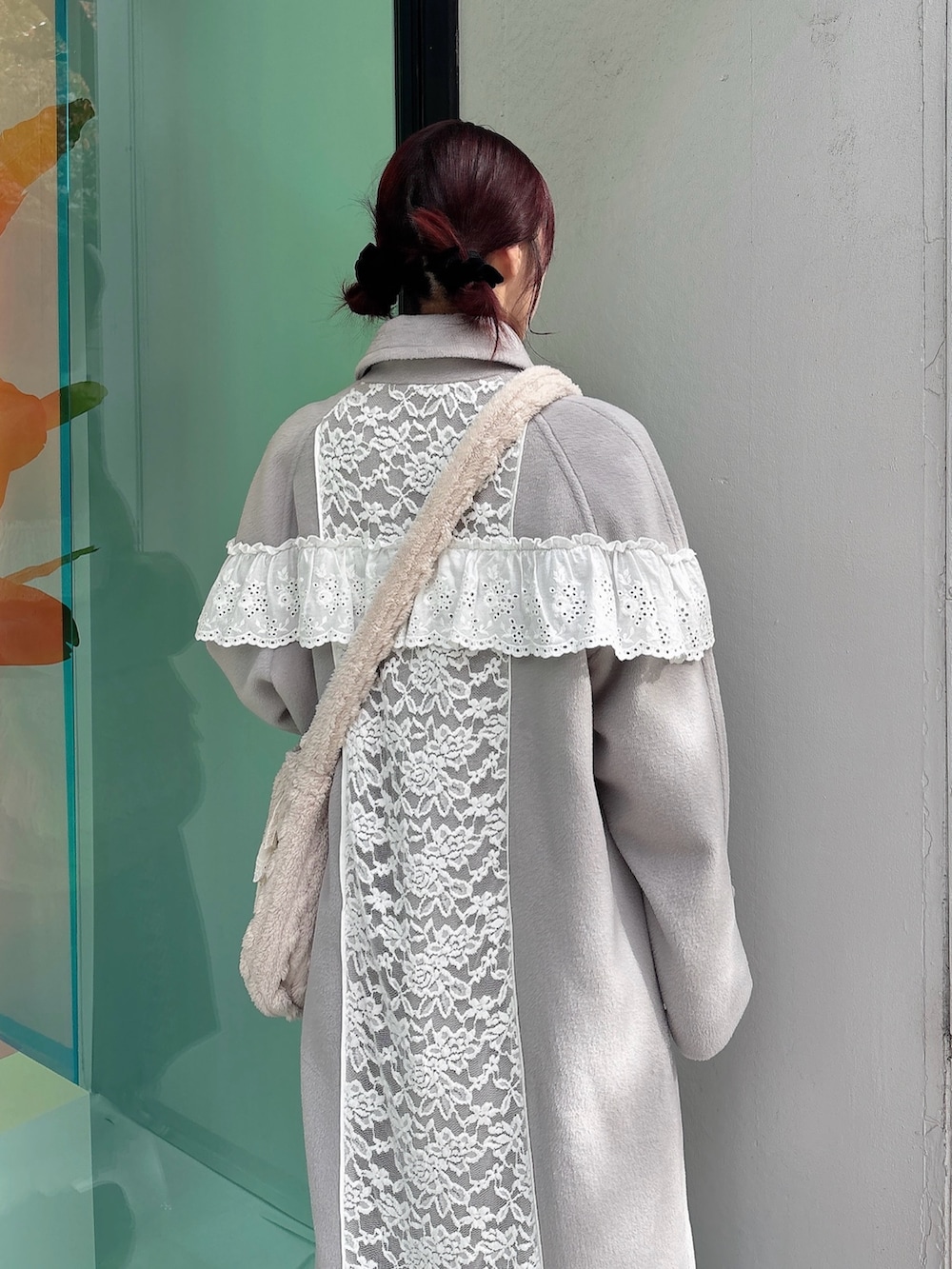 グレー系のチェスターコート、ベージュ系のショルダーバッグ、ホワイト系のワンピースを着用したレディースの秋コーディネートの4枚目の写真