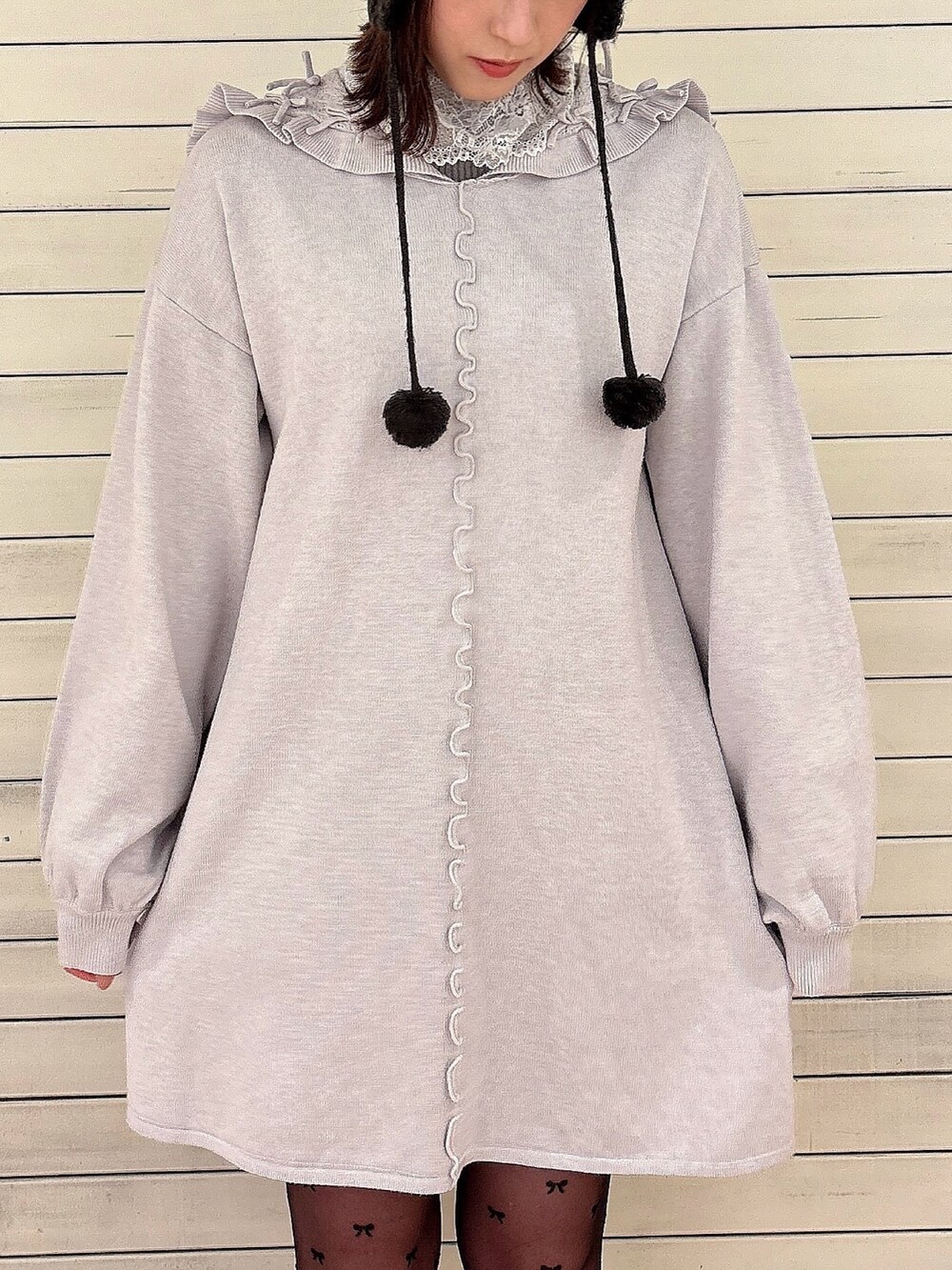 グレー系のニット/セーター、ブラウン系のノーカラーコート、ブルー系のワンピースを着用したレディースの冬コーディネートの6枚目の写真