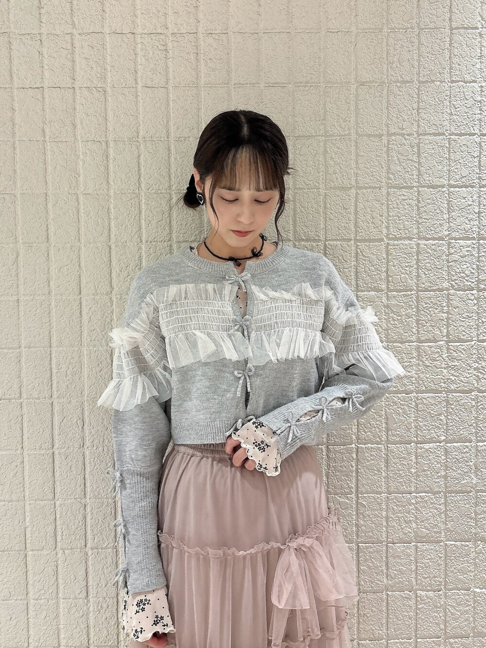 ホワイト系のTシャツ/カットソー、グレー系のカーディガン/ボレロ、ピンク系のスカートを着用したレディースの秋コーディネートの3枚目の写真