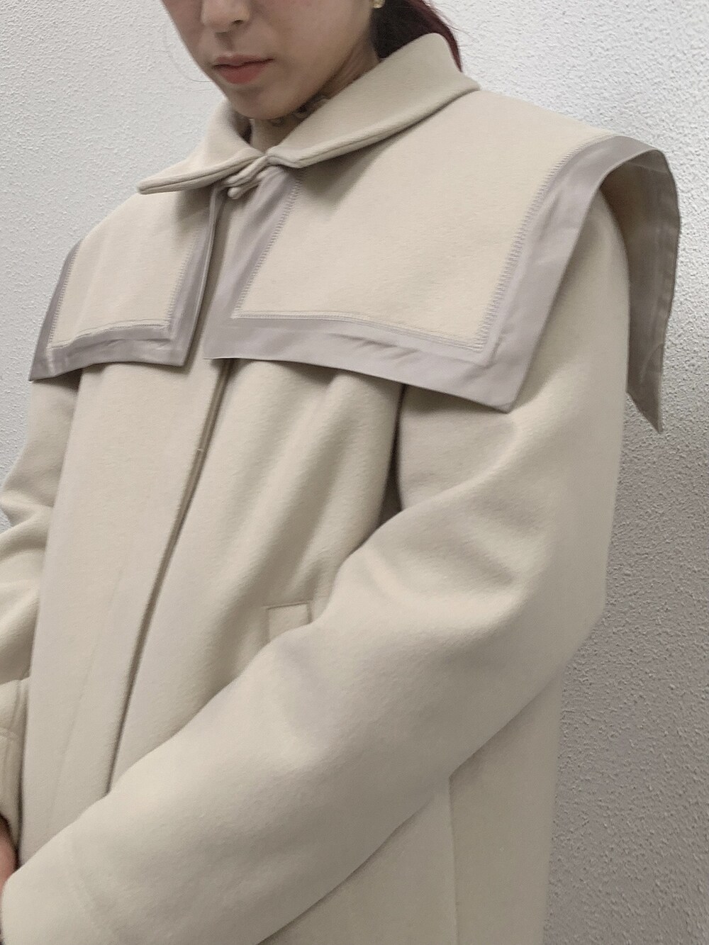 ホワイト系のニット/セーター、ブラウン系のスカート、ホワイト系のトートバッグを着用したレディースの秋コーディネートの3枚目の写真