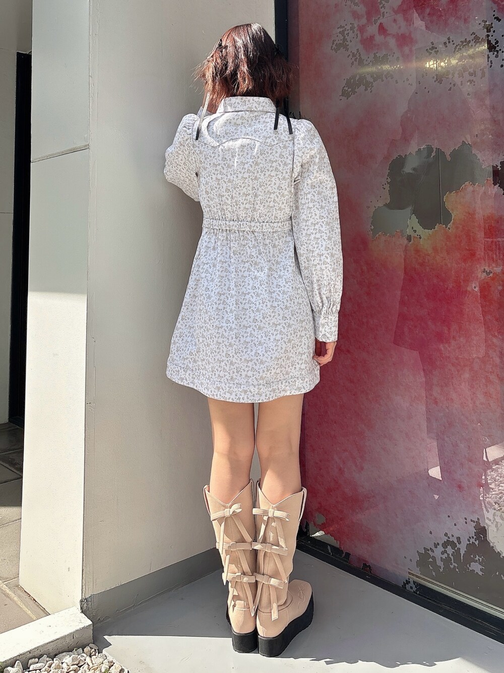 ホワイト系のワンピース、ピンク系のブーツを着用したレディースの春コーディネートの2枚目の写真