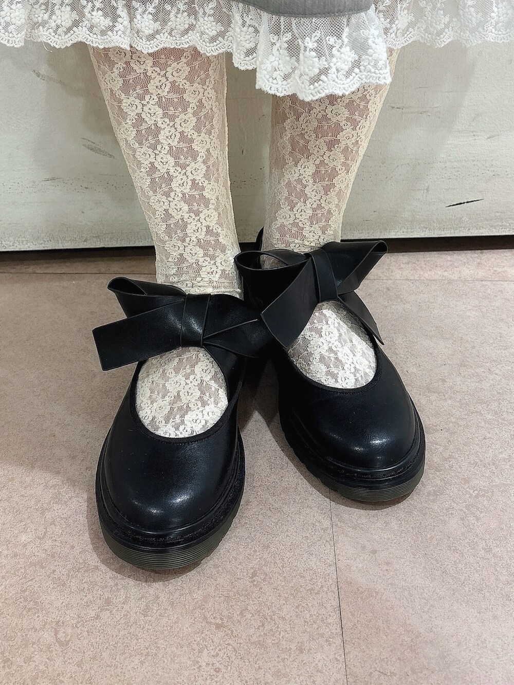 グレー系のカーディガン/ボレロ、グレー系のスカート、ブラック系のバレエシューズを着用したレディースの秋コーディネートの7枚目の写真