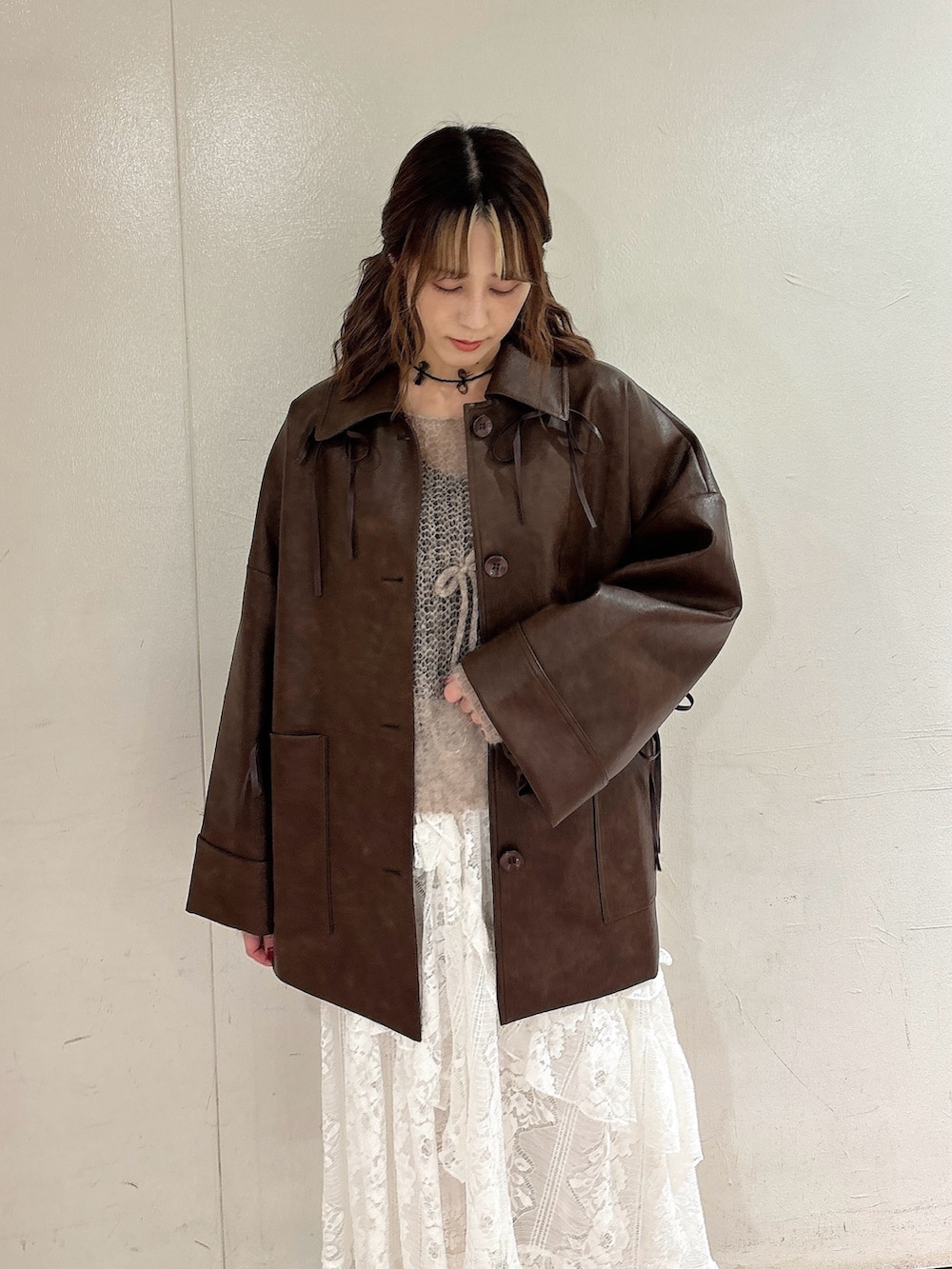 ブラウン系のブルゾン、ブラウン系のニット/セーター、ホワイト系のスカートを着用したレディースの秋コーディネートの3枚目の写真