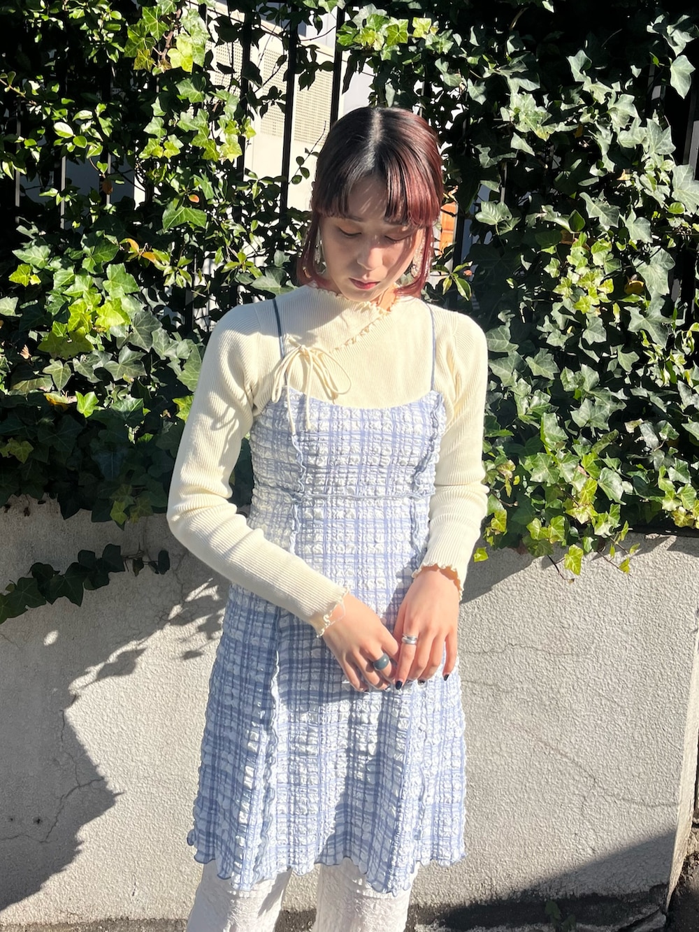 ブラック系のスラックス、ブルー系のパンプス、ブルー系のワンピースを着用したレディースの冬コーディネートの2枚目の写真