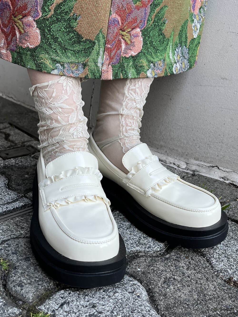 ピンク系のシャツ/ブラウス、ブラウン系のジャンパースカート、ホワイト系のハンドバッグを着用したレディースの春コーディネートの3枚目の写真