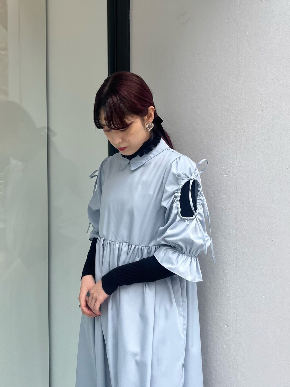 ブラック系のスニーカー、ブルー系のワンピース、ブラック系のニット/セーターを着用したレディースの冬コーディネートの2枚目の写真