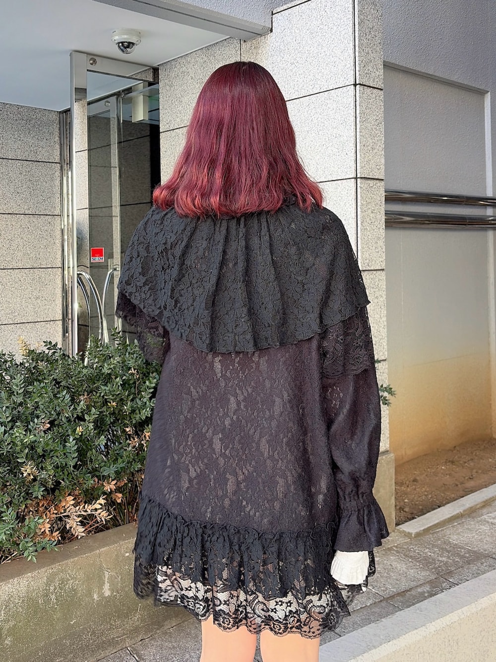 ブラック系のテーラードジャケット、ピンク系のスカート、ブラック系のスニーカーを着用したレディースの冬コーディネートの4枚目の写真