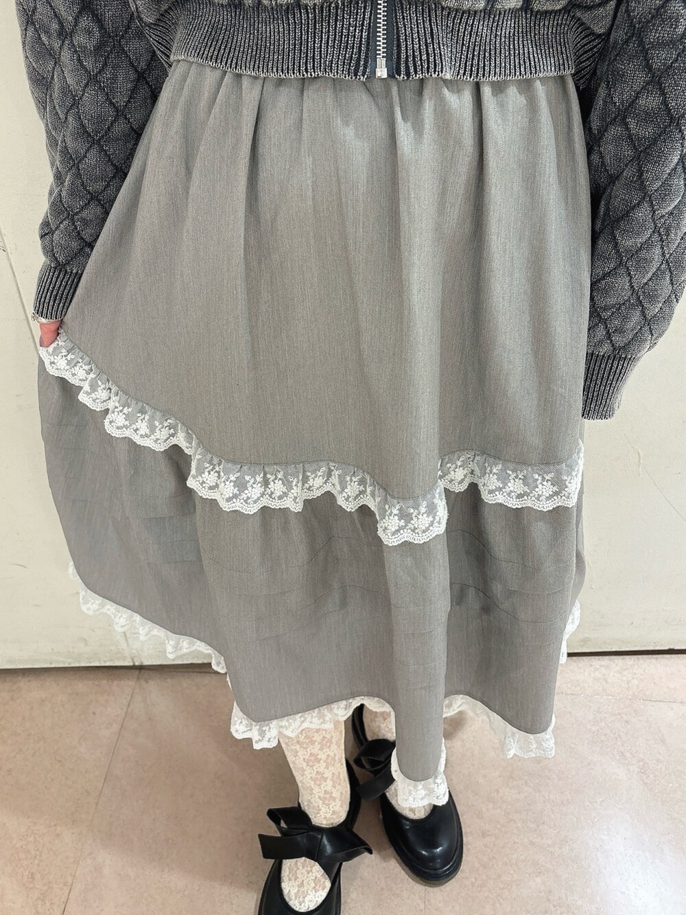 グレー系のカーディガン/ボレロ、グレー系のスカート、ブラック系のバレエシューズを着用したレディースの秋コーディネートの6枚目の写真