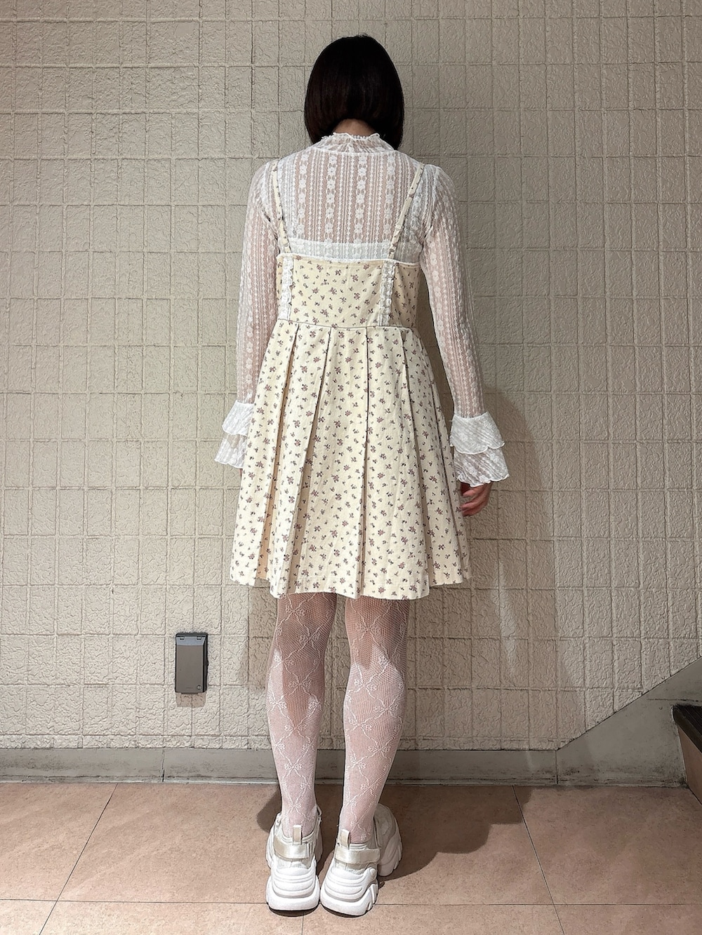 ホワイト系のワンピース、ホワイト系のスニーカー、ホワイト系のTシャツ/カットソーを着用したレディースの春コーディネートの2枚目の写真