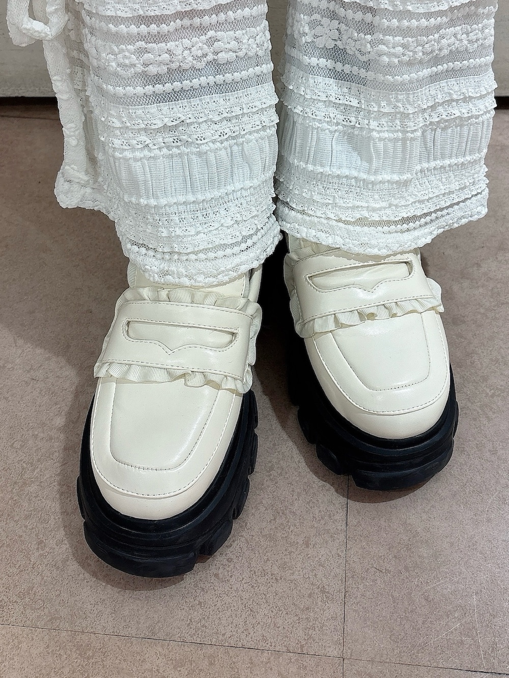 ホワイト系のその他パンツ、ホワイト系のローファー、ブルー系のカーディガン/ボレロを着用したレディースの冬コーディネートの7枚目の写真