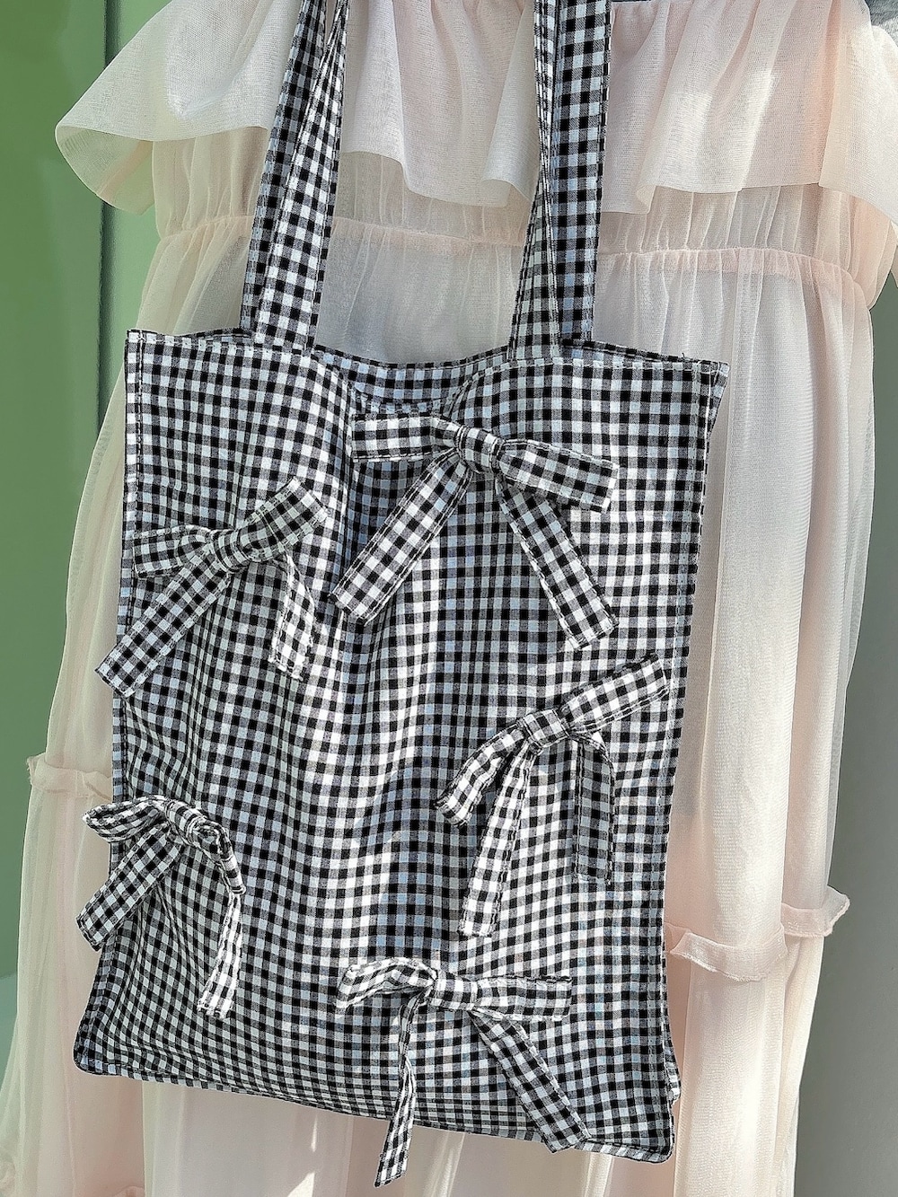 ピンク系のワンピース、ブルー系のスニーカー、ブラック系のトートバッグを着用したレディースの冬コーディネートの4枚目の写真