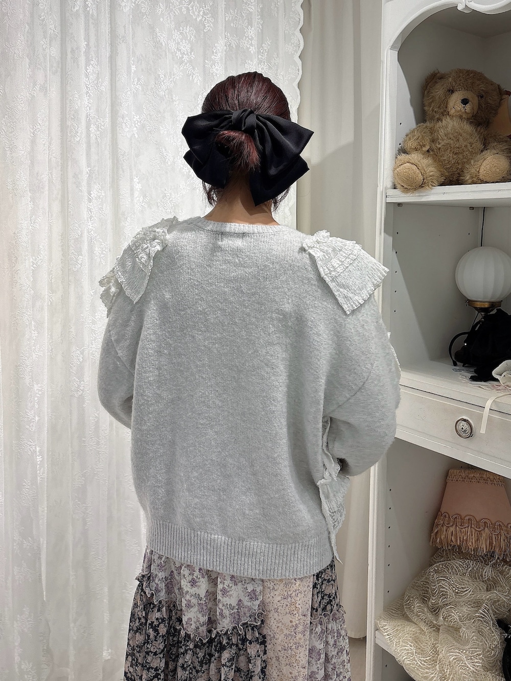 グレー系のニット/セーター、ブラック系のスカート、ピンク系のブーツを着用したレディースの秋コーディネートの4枚目の写真