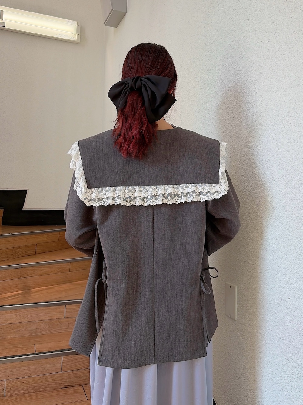 ブルー系のワンピース、ブラック系のパンプス、グレー系のテーラードジャケットを着用したレディースの春コーディネートの4枚目の写真