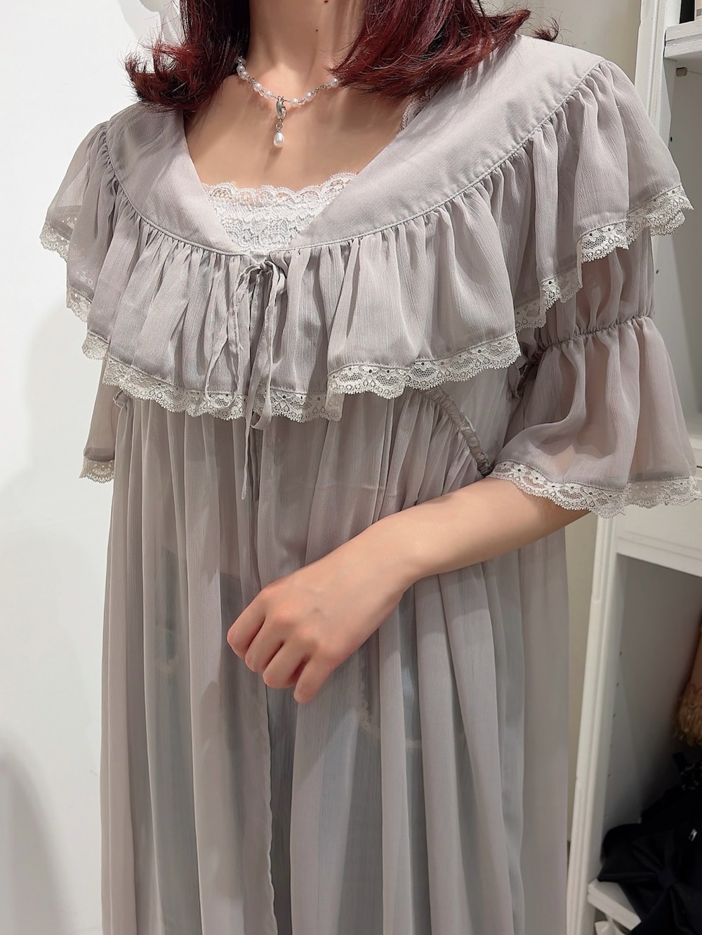 グレー系のワンピース、ホワイト系のキャミソール、ブルー系のデニムパンツを着用したレディースの春コーディネートの5枚目の写真