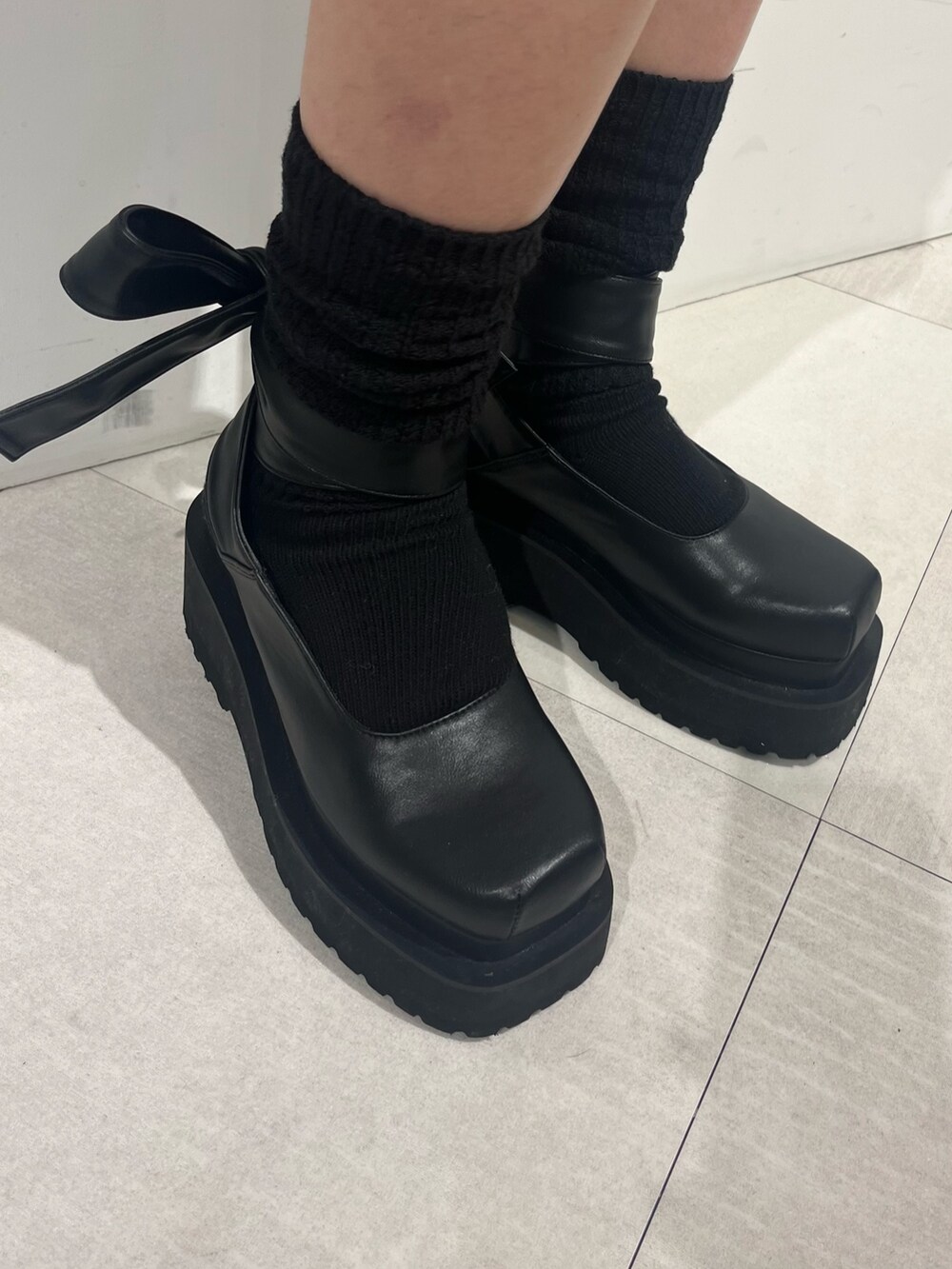 ブラック系のパンプス、ピンク系のTシャツ/カットソー、ブラック系のニット/セーターを着用したレディースの冬コーディネートの3枚目の写真