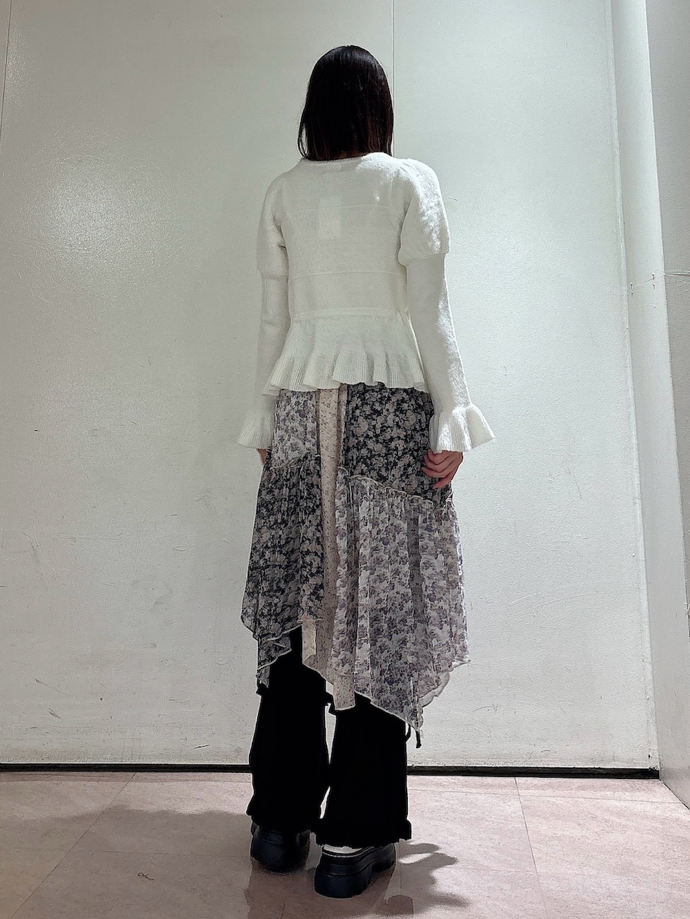 ホワイト系のニット/セーター、ブラック系のスカート、ブラック系のスウェットパンツを着用したレディースの秋コーディネートの2枚目の写真