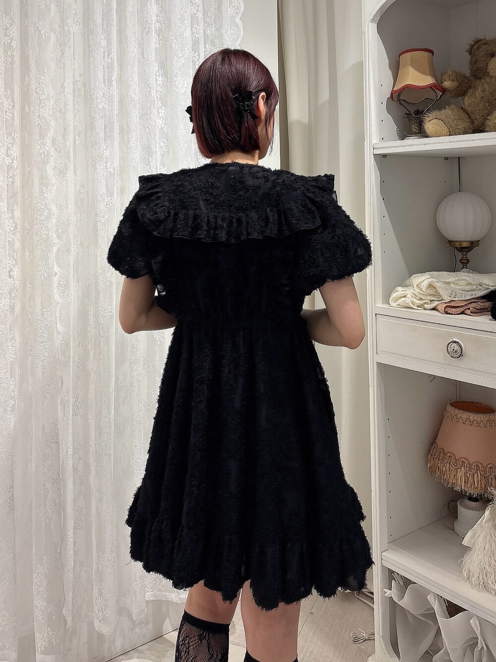 ブラック系のワンピース、ブラック系のサンダル、レッド系のハンドバッグを着用したレディースの夏コーディネートの4枚目の写真