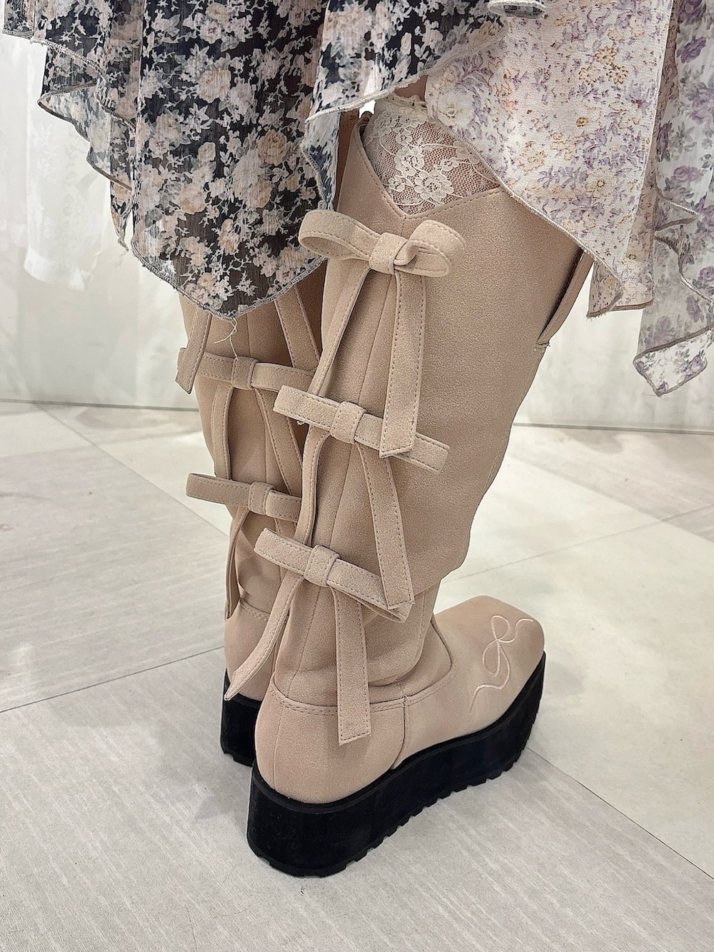 グレー系のニット/セーター、ブラック系のスカート、ピンク系のブーツを着用したレディースの秋コーディネートの7枚目の写真