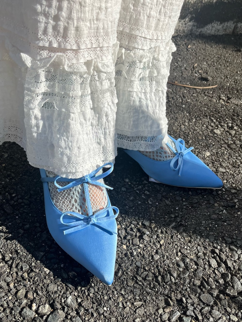 ブラック系のスラックス、ブルー系のパンプス、ブルー系のワンピースを着用したレディースの冬コーディネートの3枚目の写真