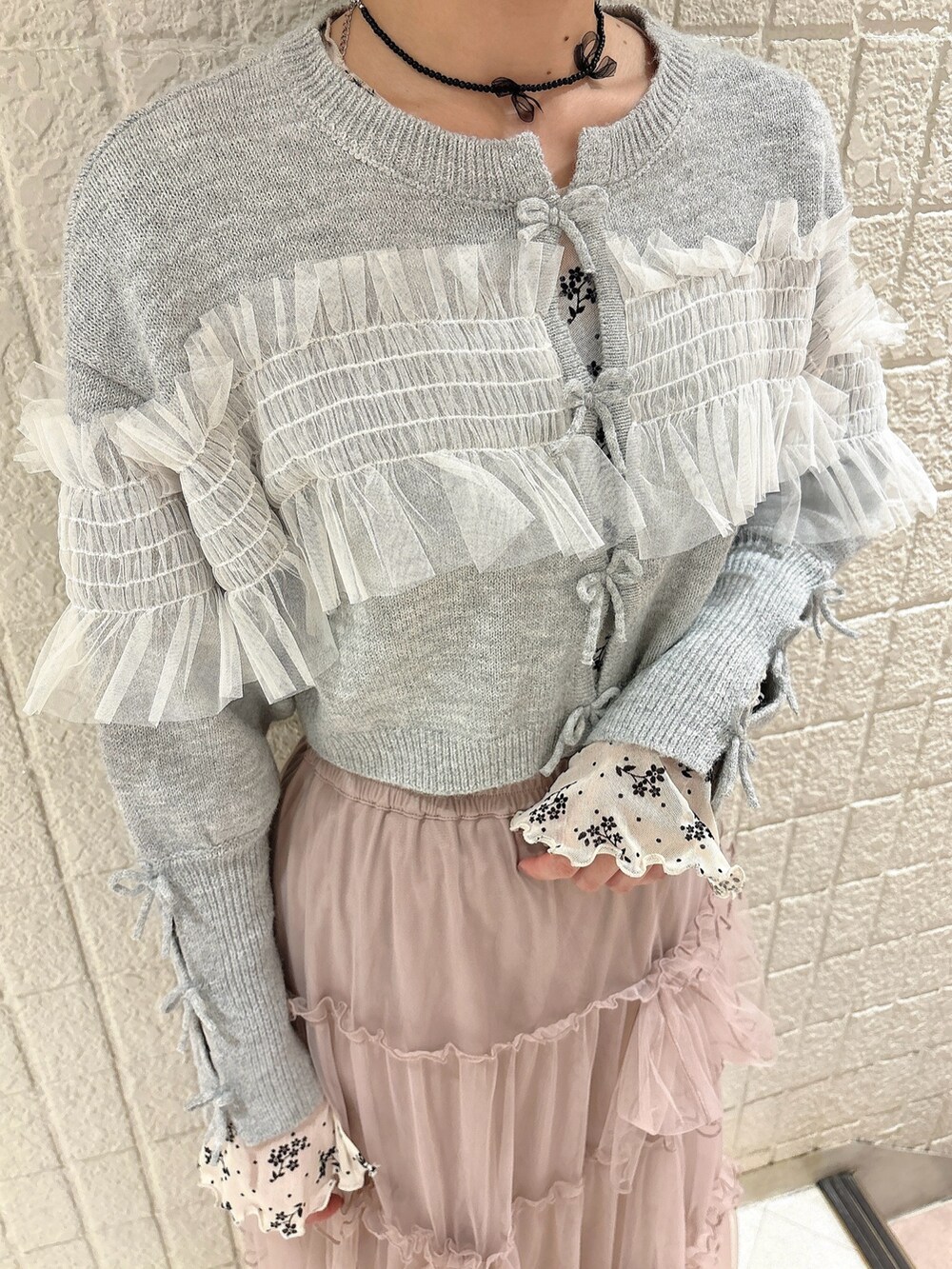 ホワイト系のTシャツ/カットソー、グレー系のカーディガン/ボレロ、ピンク系のスカートを着用したレディースの秋コーディネートの5枚目の写真