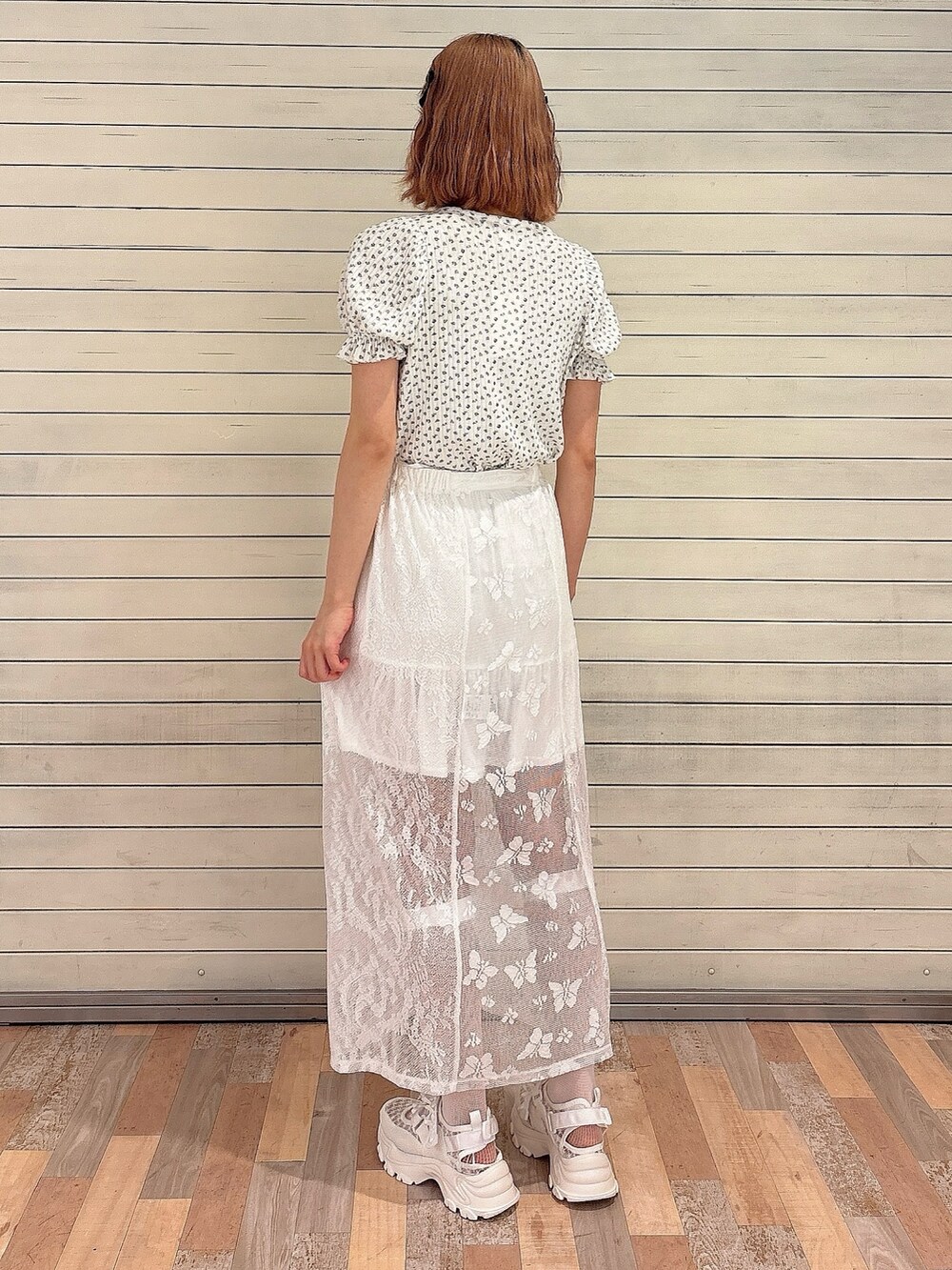 ホワイト系のスカート、ホワイト系のスニーカー、ブルー系のTシャツ/カットソーを着用したレディースの春コーディネートの2枚目の写真