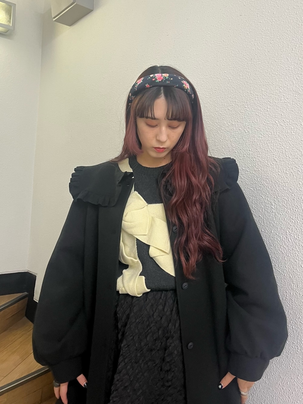 ブラック系のスカート、ベージュ系のブーツ、ブラック系のその他アウターを着用したレディースの冬コーディネートの2枚目の写真