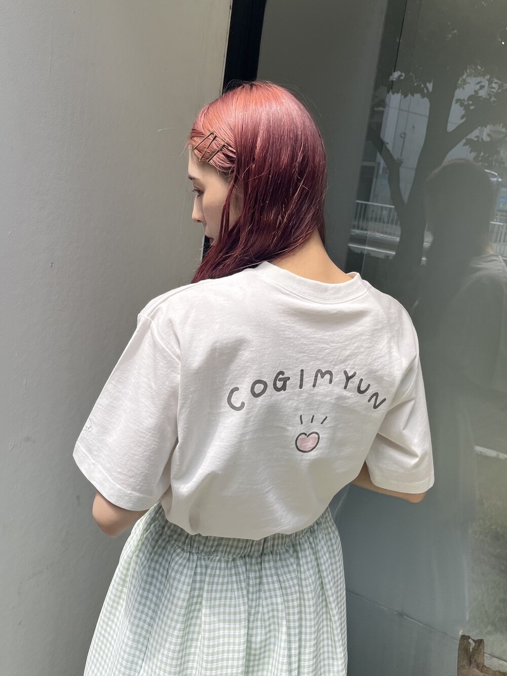 グリーン系のスカート、ホワイト系のスニーカー、ホワイト系のTシャツ/カットソーを着用したレディースの夏コーディネートの3枚目の写真