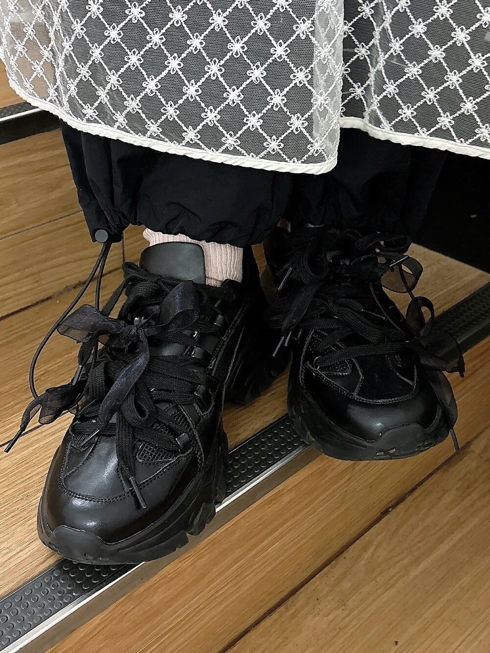 ホワイト系のワンピース、ブラック系のカーゴパンツ、ブラック系のスニーカーを着用したレディースの冬コーディネートの5枚目の写真