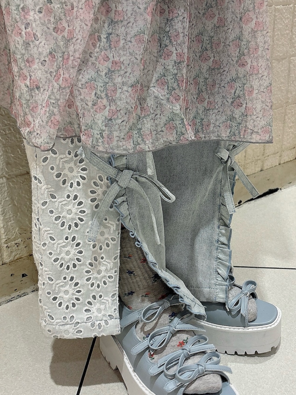 ピンク系のワンピース、ブルー系のデニムパンツ、ブルー系のサンダルを着用したレディースの夏コーディネートの6枚目の写真