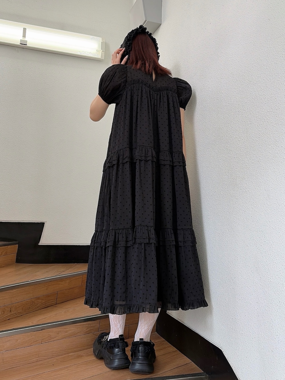 ブラック系のワンピース、ブラック系のスニーカー、ブラック系のカチューシャを着用したレディースの春コーディネートの2枚目の写真