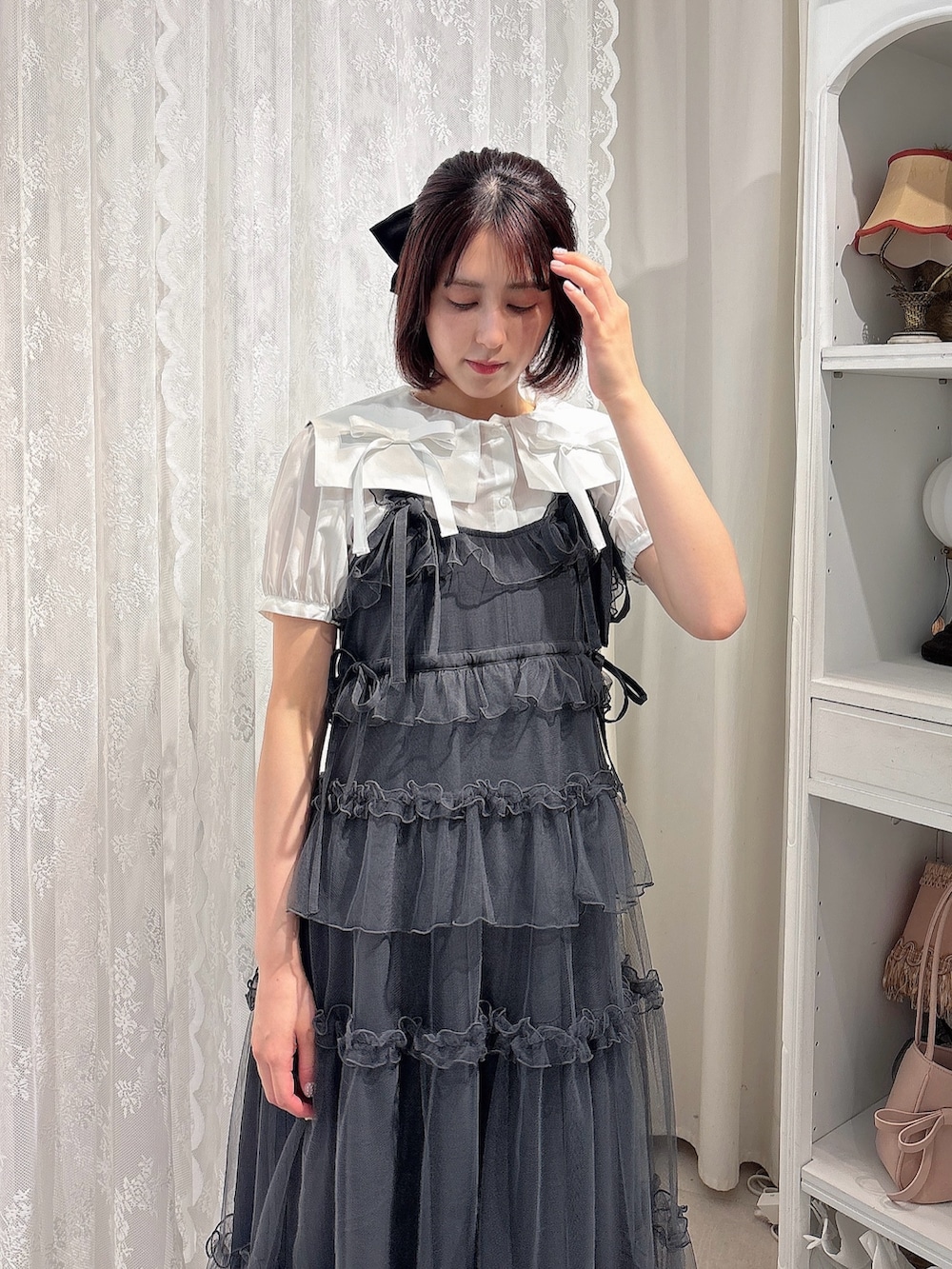 グレー系のワンピース、ホワイト系のシャツ/ブラウス、ブラック系のブーツを着用したレディースの夏コーディネートの3枚目の写真