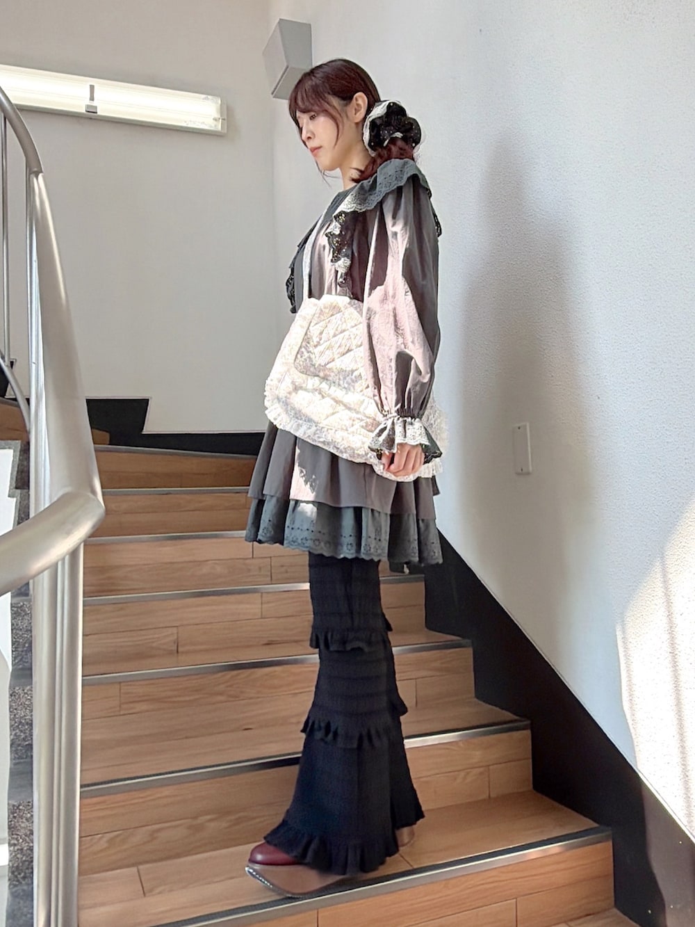 グレー系のワンピース、ホワイト系のショルダーバッグ、ブラック系のその他パンツを着用したレディースの夏コーディネートの2枚目の写真
