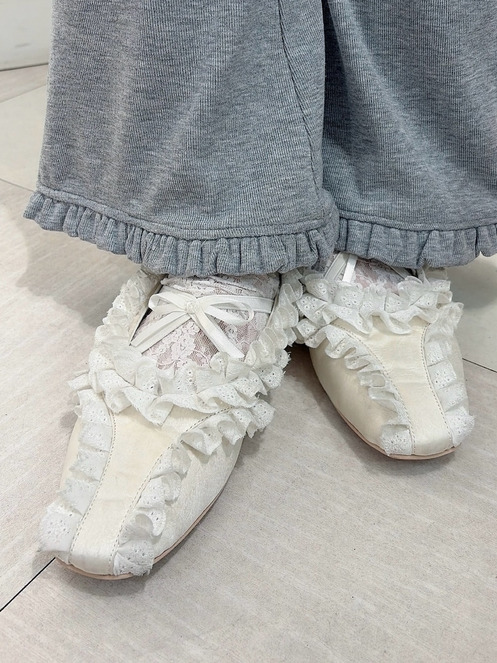 グレー系のスウェット、グレー系のスウェットパンツ、ホワイト系のバレエシューズを着用したレディースの冬コーディネートの6枚目の写真