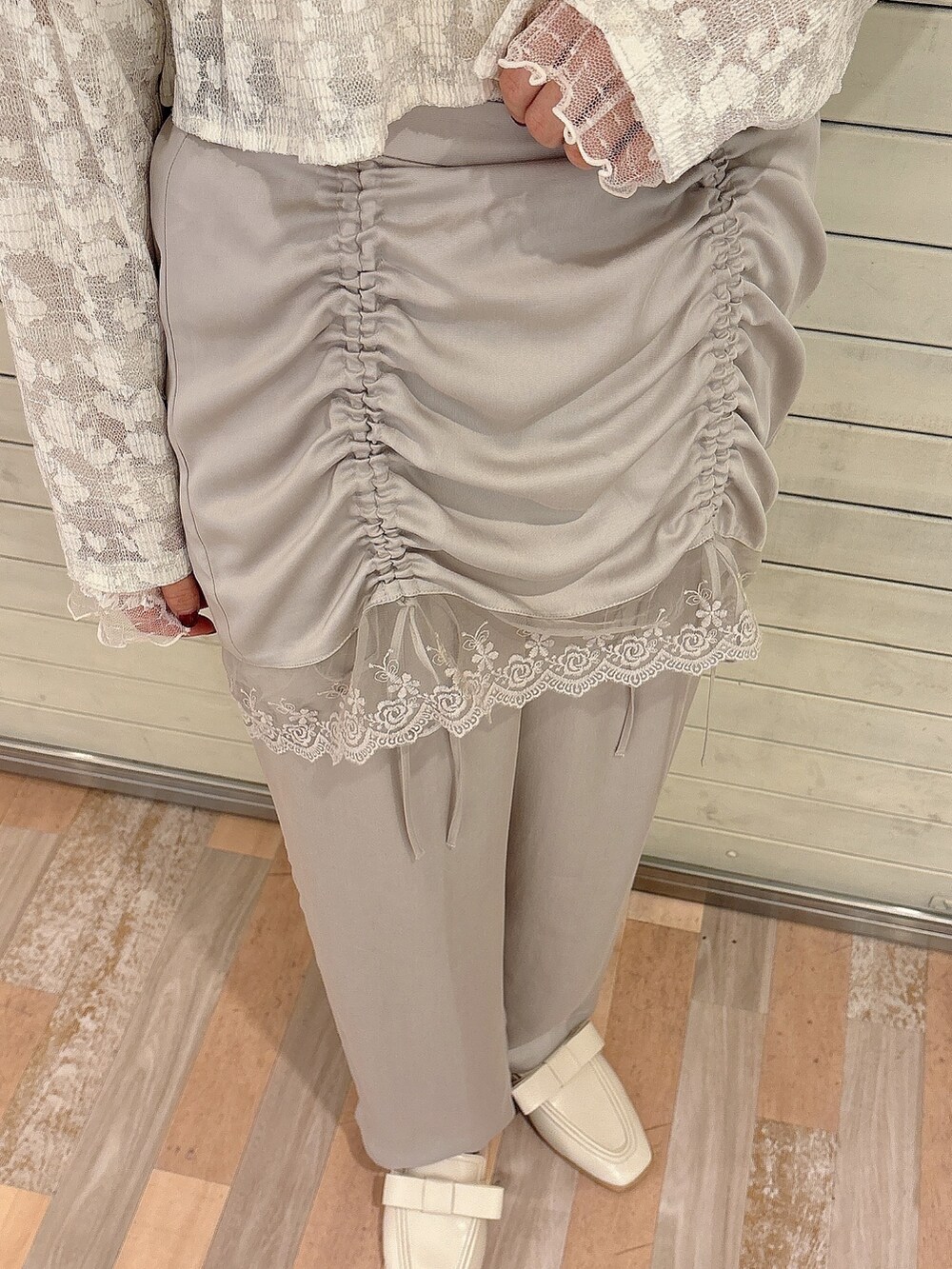 グレー系のスラックス、ホワイト系のローファー、ホワイト系のTシャツ/カットソーを着用したレディースの夏コーディネートの6枚目の写真