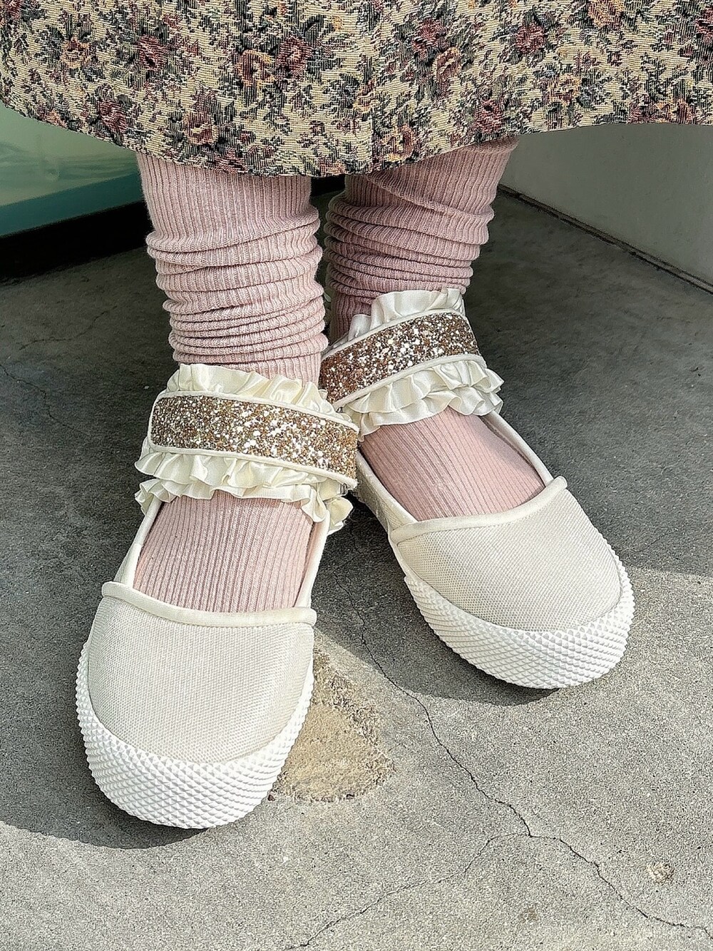 ベージュ系のジャンパースカート、ホワイト系のニット/セーター、ブラック系のニット/セーターを着用したレディースの冬コーディネートの4枚目の写真