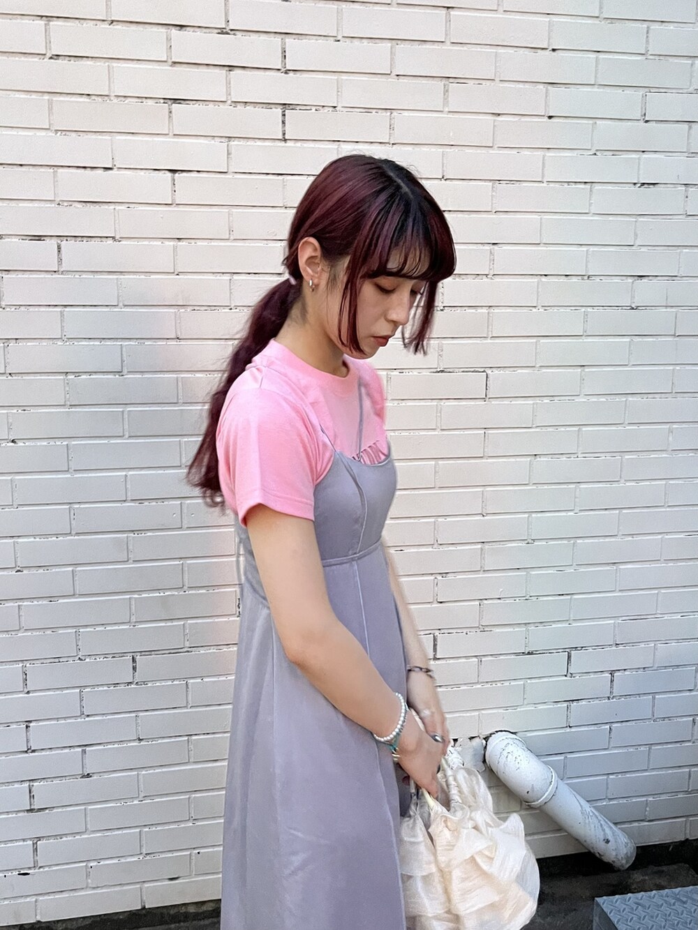 ホワイト系のハンドバッグ、ホワイト系のサンダル、ブルー系のワンピースを着用したレディースの夏コーディネートの2枚目の写真