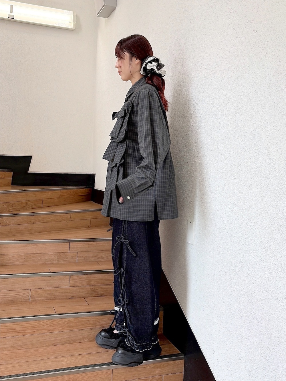 グリーン系のシャツ/ブラウス、ブルー系のデニムパンツ、ブラック系のスニーカーを着用したレディースの秋コーディネートの2枚目の写真