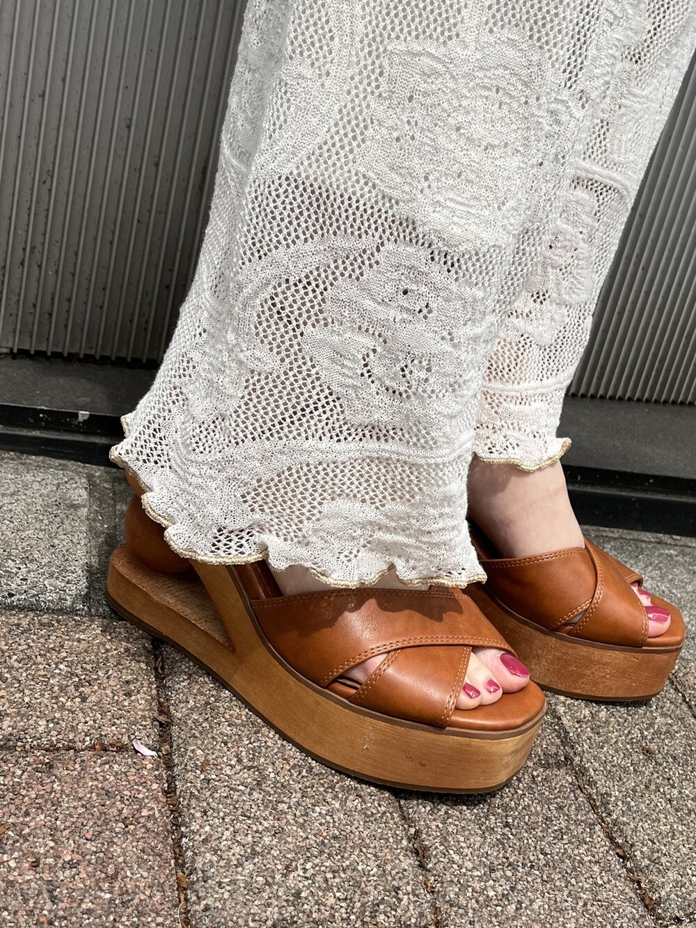 ホワイト系のその他パンツ、オレンジ系のハンドバッグ、ブラウン系のサンダルを着用したレディースの春コーディネートの3枚目の写真